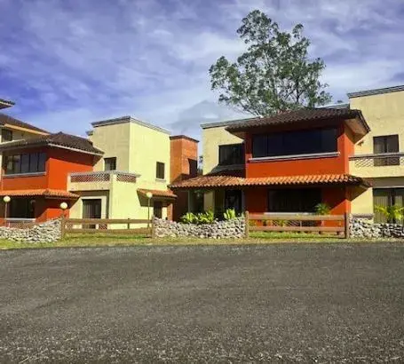 Two-tone houses with tiled roofs and lawns at Boquete Country Club, under a clouded highland sky