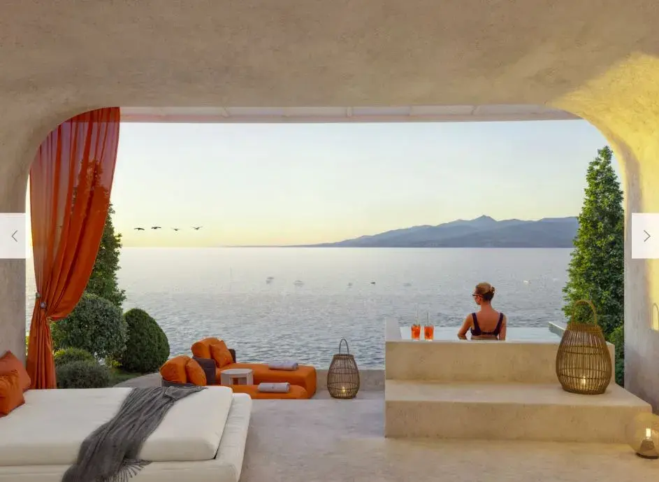 A Cavarossa interior framing an arched opening onto the bay, with a plunge pool on the terrace