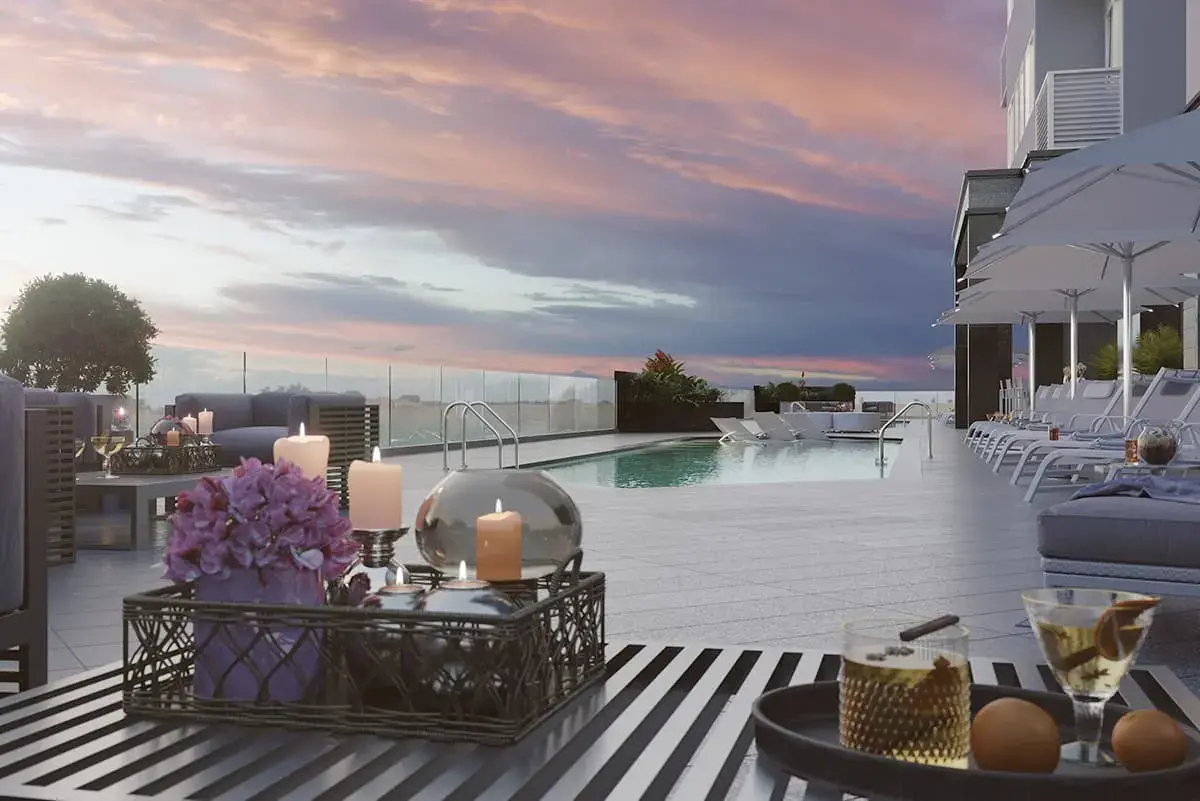 Empire Residences' rooftop deck at sunset, with a pool, striped paving and a dressed table