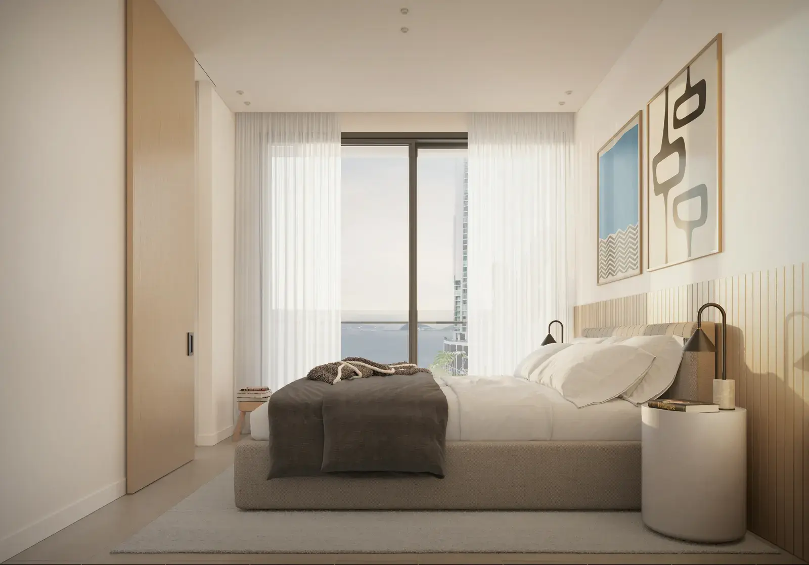A Mantra bedroom, with full-height glazing and framed artwork above the bedside