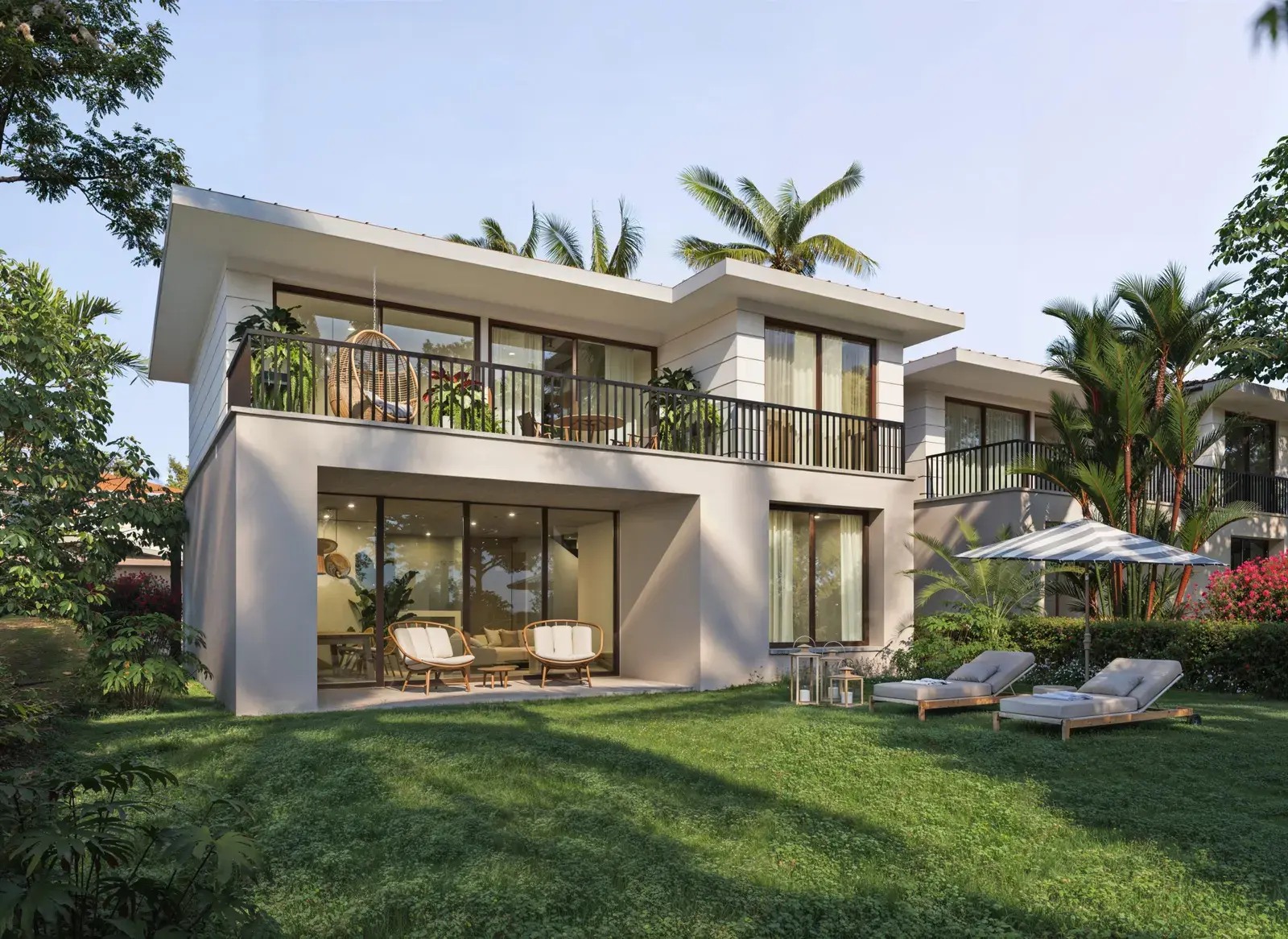 Two Venao Living villas seen from the lawn, with palms and loungers between them