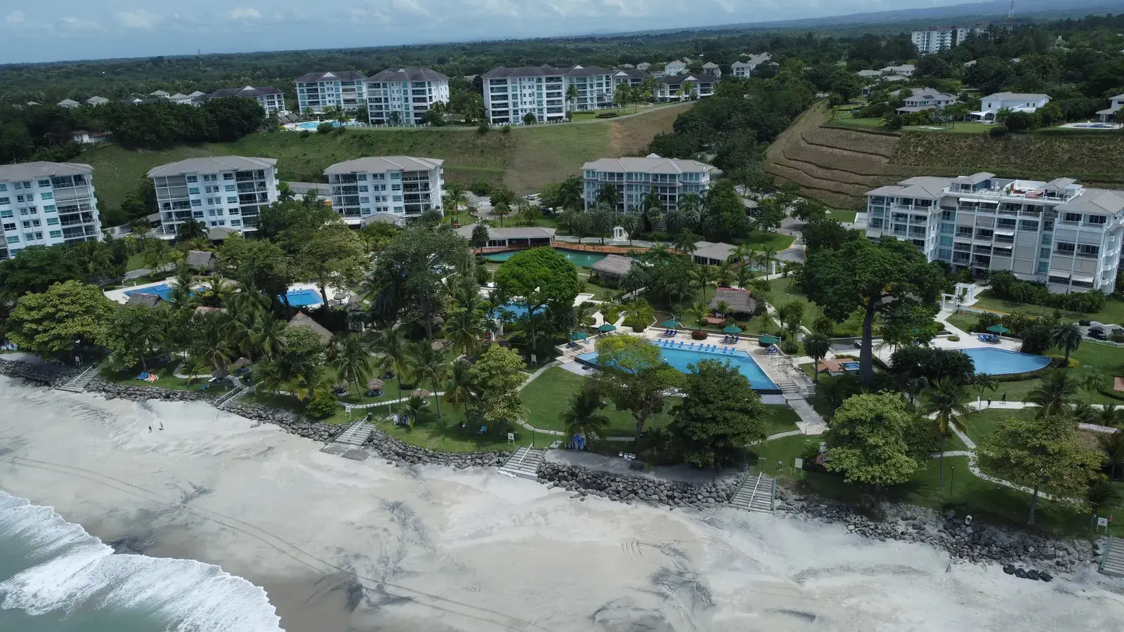The Bijao buildings seen from the shoreline, set among lawns and mature trees