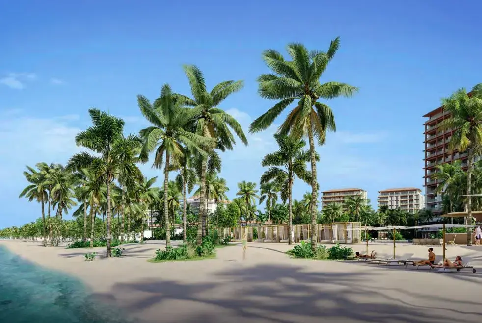 Tall palms lining the beach at Buenaventura, with the resort's residential buildings behind the sand