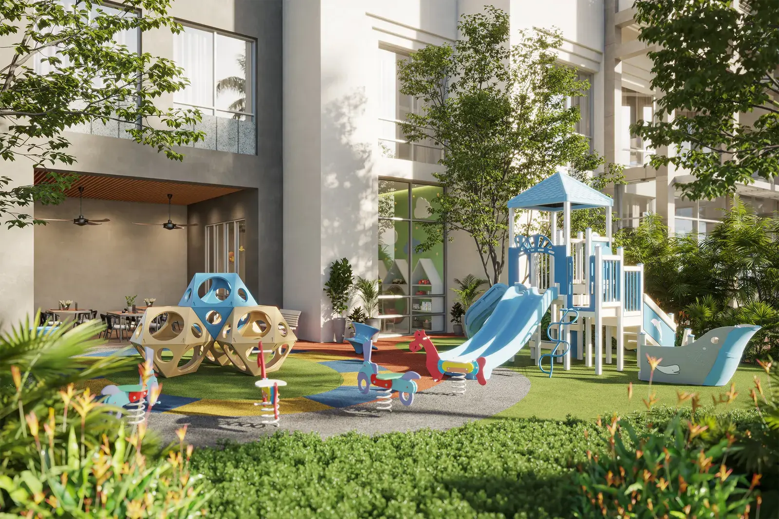 Corotú's children's play area, with climbing frames and slides set in landscaped lawn between the buildings