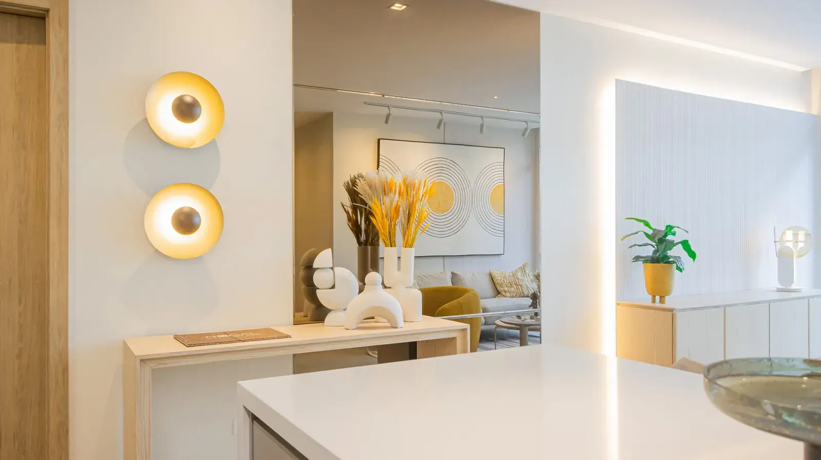 A Nogal entrance hall, with a console, wall lights and an open plan beyond