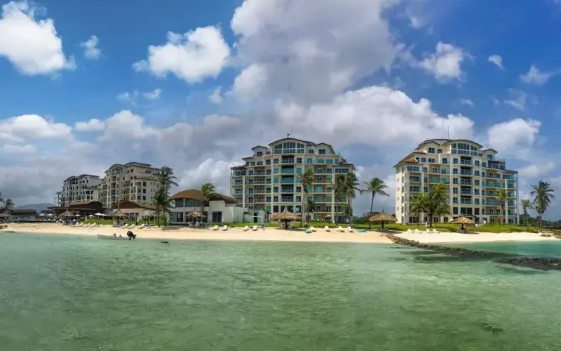The Playa Escondida resort seen from the water, low buildings along a calm Caribbean shore
